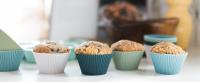 Free-standing silicone baking cups in white, navy, sage, and light blue with muffins in them