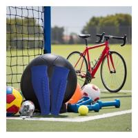 A soccer field with a ball and cleats in the foreground, showcasing the product in action.
