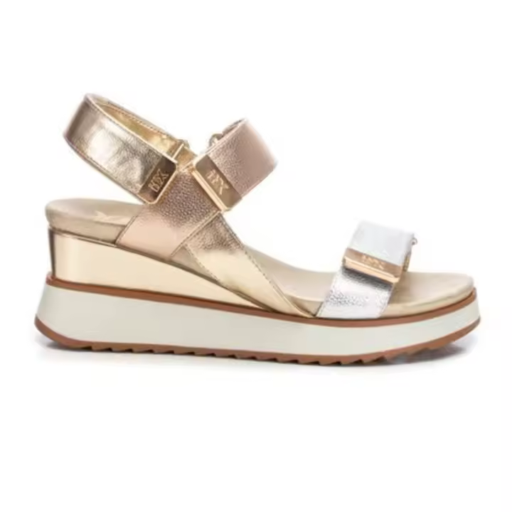 XTI 143882 Sandalia de mujer de la marca XTI. Fabricada en material imitación piel en color oro y plata. Tira y pulsera al tobillo con velcro para una mejor adaptación al pie. Suela con cuña y plataforma de goma antideslizante. - 1