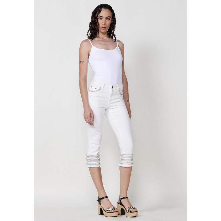 Koröshi Women's Medium Rise Capri Push Up Jeans with Five Pockets and Distressed Hem Embroidery, made of 98% Cotton and 2% Elastane for a flattering fit, perfect for stylish casual or dressy looks.