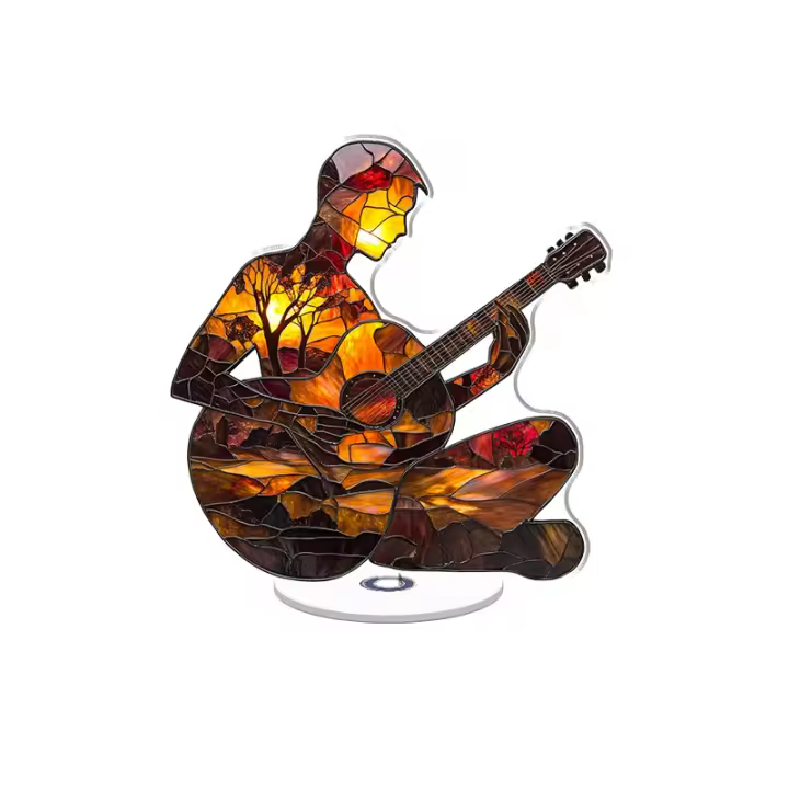 Un adorno acrílico giratorio que representa a un músico de vidrieras con una guitarra entre escenas vibrantes de la naturaleza en colores luminosos. - 1