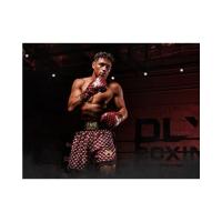 Un boxeador musculoso erguido, con guantes de boxeo Venum y pantalones cortos de boxeo Venum