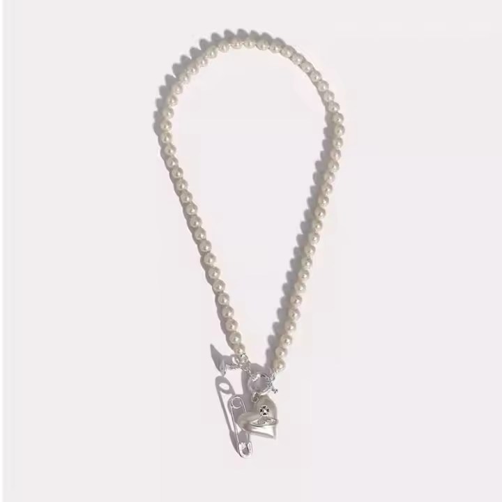 Vīvīеппе Westwood Sheryl Collar de perlas Asimétrico en forma de corazón y motivo de pasador de seguridad Tallado de orbe de Saturno en tono dorado - 1