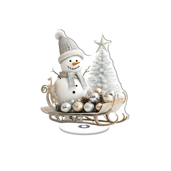 Adorno acrílico giratorio con un lindo muñeco de nieve con sombrero y bufanda junto a un trineo de madera lleno de juguetes de vidrio plateado y árboles blancos dorados. - 1