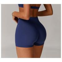 Una mujer con pantalones cortos de yoga de cintura alta que levantan la cadera sobre pantalones cortos deportivos ajustados, adelgazantes y para correr. - details 1