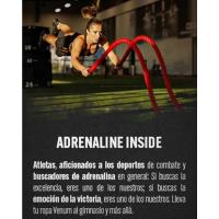 Un atleta en el aire haciendo ejercicios de fuerza y acondicionamiento en un gimnasio.