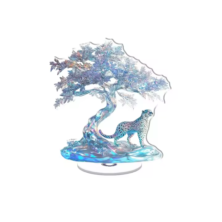 La exhibición acrílica giratoria presenta un leopardo de las nieves y un fénix helado bajo un árbol de hielo que muestra colores iridiscentes y detalles intrincados sobre un fondo blanco. - 1