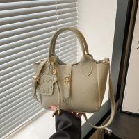 Bolso de mano elegante con forma de cubo cruzado inclinado, bolso de mano con colgante de cachorro para mujer, bolso de hombro de cuero de PU de alta gama con patrón de lichi, primavera y verano - details 8