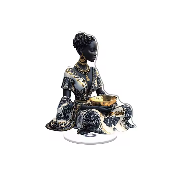 El adorno acrílico giratorio muestra una estatua de una mujer africana sentada en un cuenco dorado y con una falda con estampado negro, blanco y dorado brillante y vívido. - 1