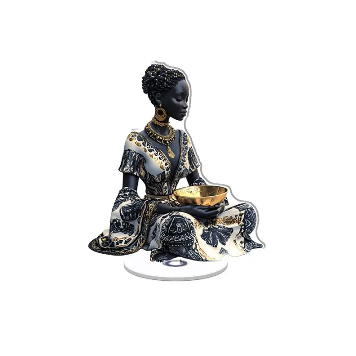 El adorno acrílico giratorio muestra una estatua de una mujer africana sentada en un cuenco dorado y con una falda con estampado negro, blanco y dorado brillante y vívido. - 1