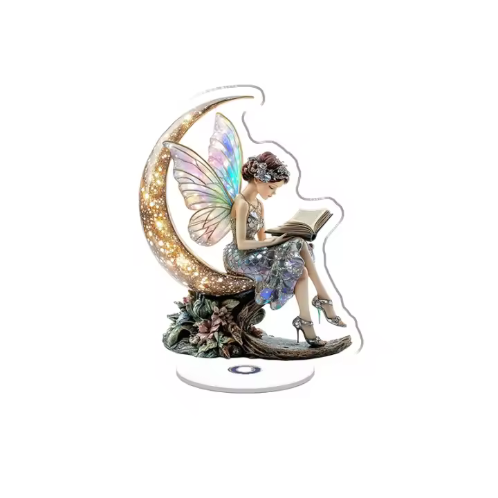 El adorno acrílico giratorio presenta una hada de cristal espejado con alas opalescentes, un vestido cosido con diamantes y una luna de cristal, todo bajo luces brillantes. - 1