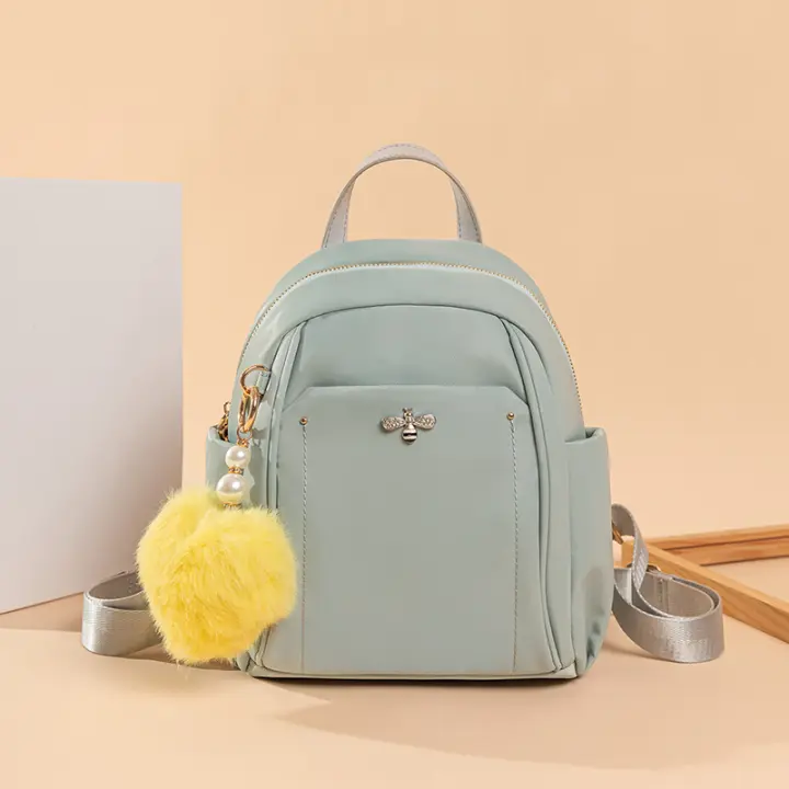 Mochilas de color verde Mochila pequeña para niña Bolsas casuales lindas y elegantes para mujer Diseño de moda Bolsas de libros ligeras fáciles de llevar con decoraciones colgantes - 1