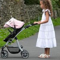 niña con cochecito en el jardín