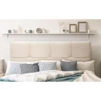 Cabecero de cama tapizado en beige, de fondo un dormitorio elegantemente decorado