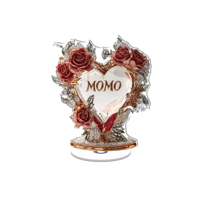 Expositor acrílico giratorio con un arco en forma de rosa y corazón con MOMO adornado con diamantes y rosas bajo una suave iluminación del atardecer. - 1