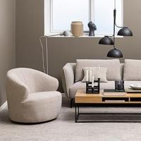 Living room environment showing a beige lounge chair, wooden coffee table and a beige sofa