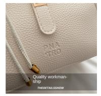Bolso de mano elegante con forma de cubo cruzado inclinado, bolso de mano con colgante de cachorro para mujer, bolso de hombro de cuero de PU de alta gama con patrón de lichi, primavera y verano - details 3